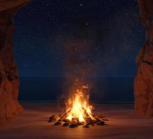 A fire on a beach at night. 