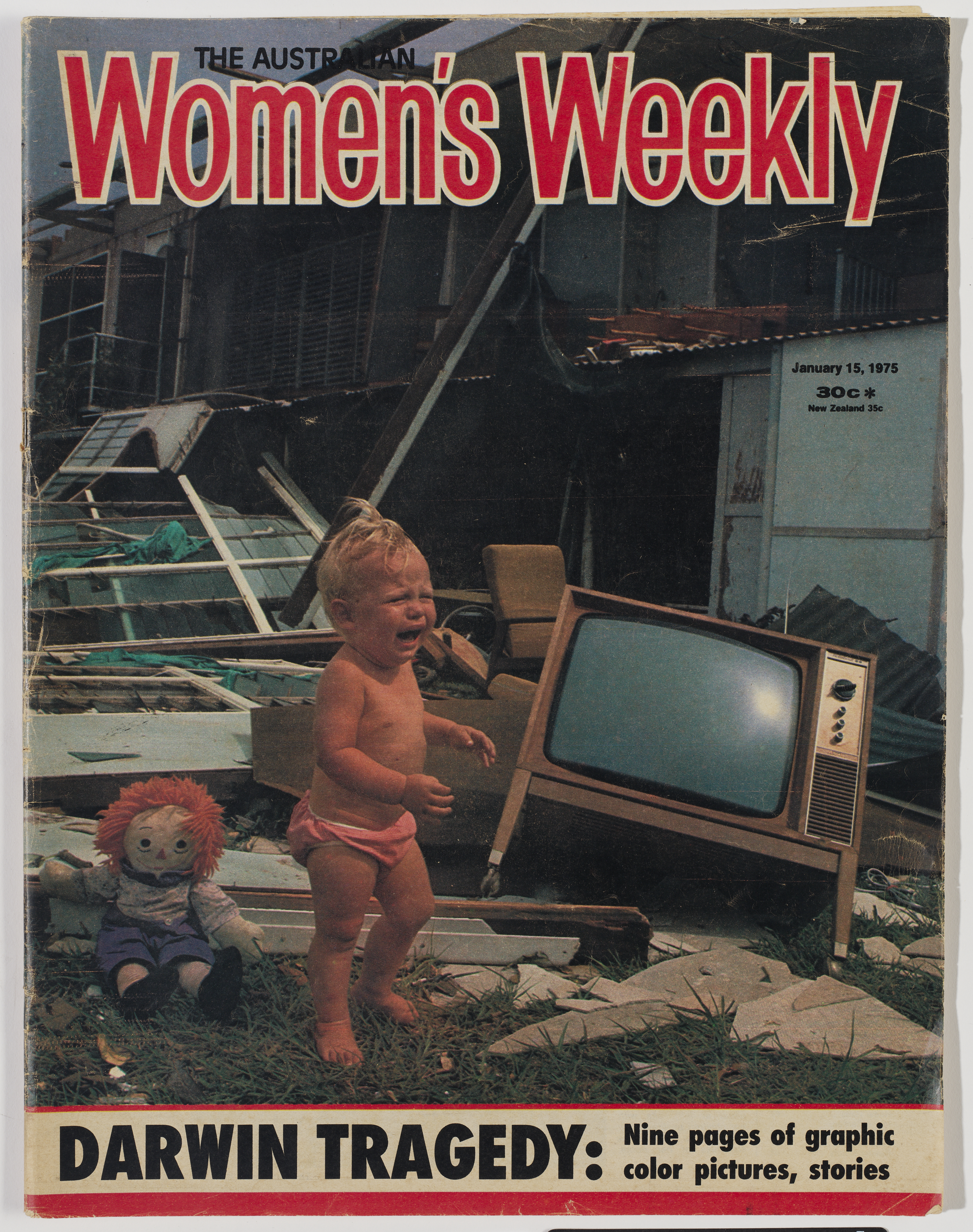 An Australian Women's Weekly cover page with the image of a child crying in the wreckage of a house with a TV and a doll in the background. 