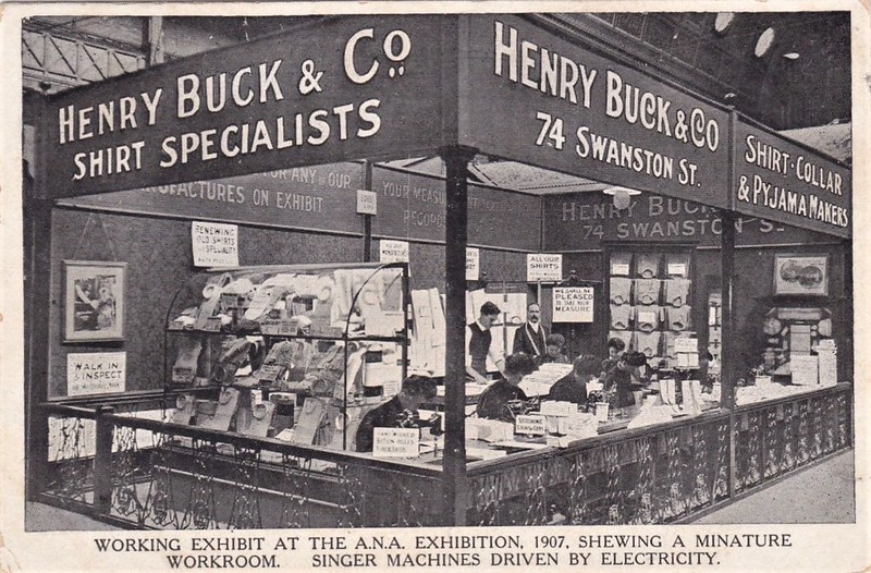 Exhibition stand for Henry Buck & Co. Shirts are displayed on the stand and there is a row of seamstresses using sewing machines.