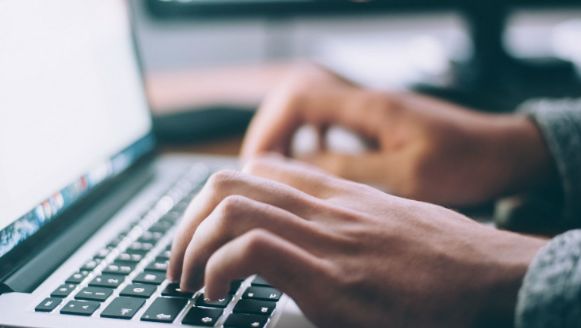 hands typing on a laptop