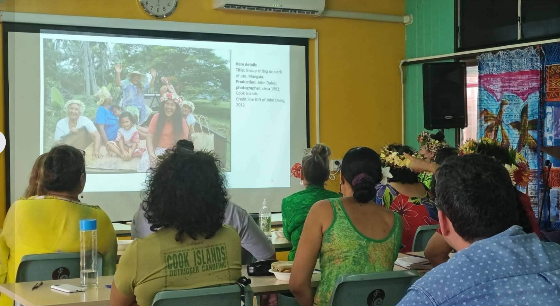 People look at photograph projected on a screen in workshop in the Cook Islands