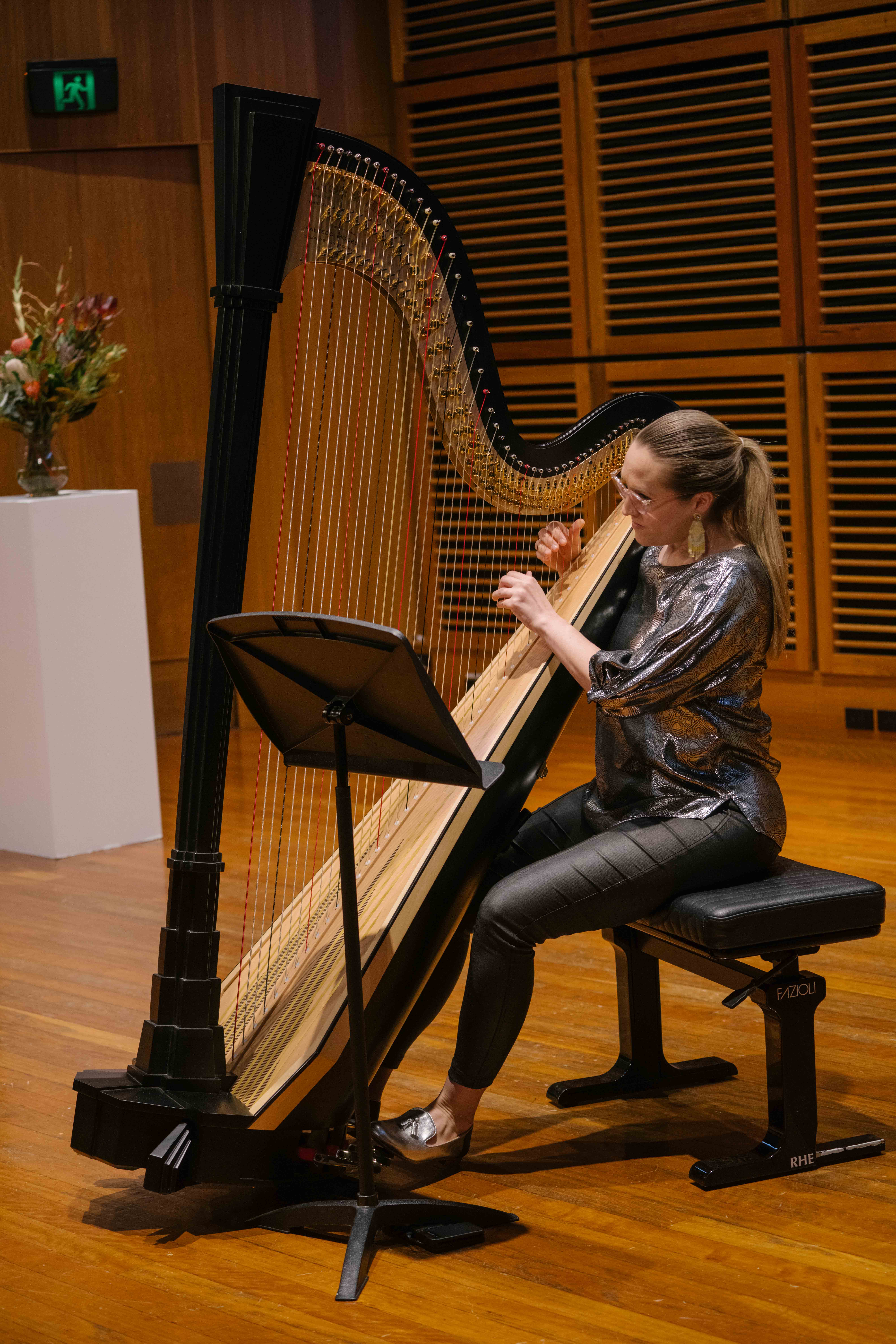 A woman playing a harp on stage