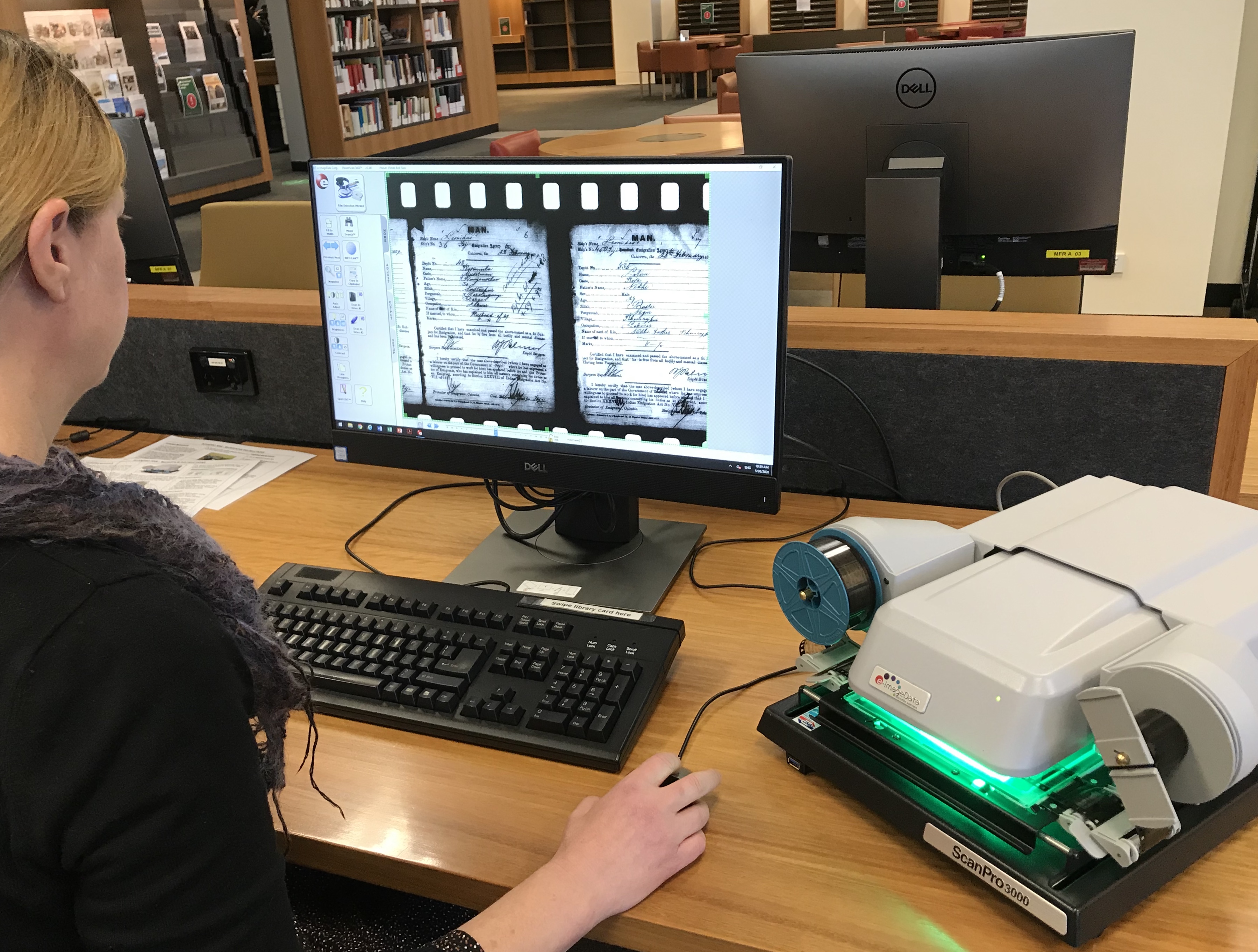 Librarian looking at a microfilm reader