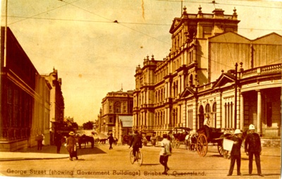An old photo of people on the street with buildings in the background.