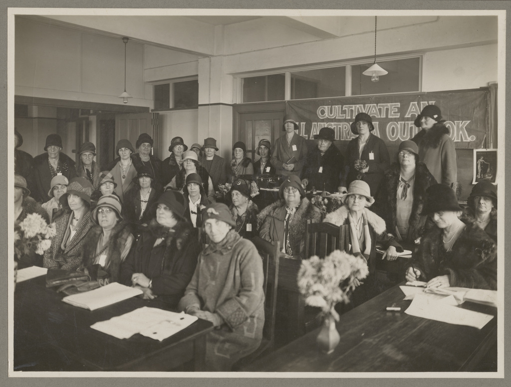 Group of women sitting in rows of chairs in an indoor meeting room