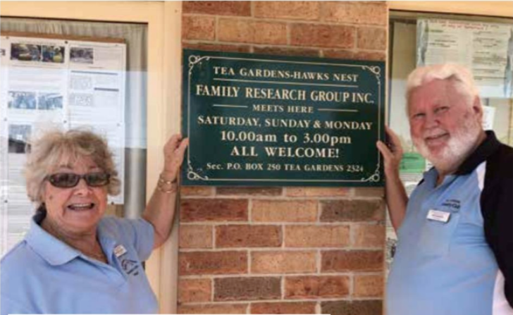 Margaret and Terry Munright with the sign for the Tea Gardens Hawks Nest Family History Group
