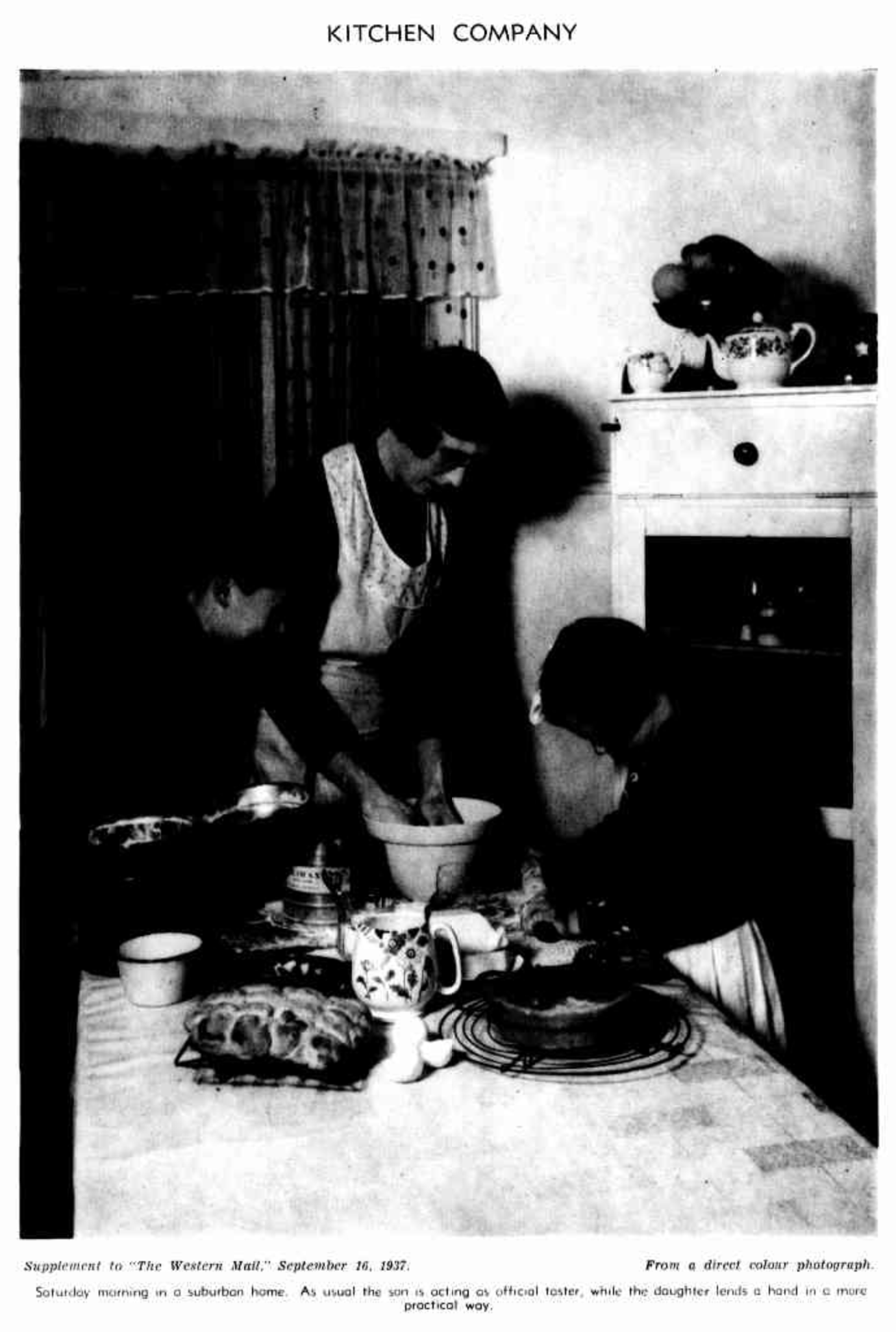 a women cooking in a kitchen accompanied by her two young children