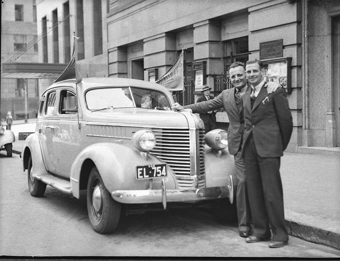 Bruce and Hubert standing together in front of a car.