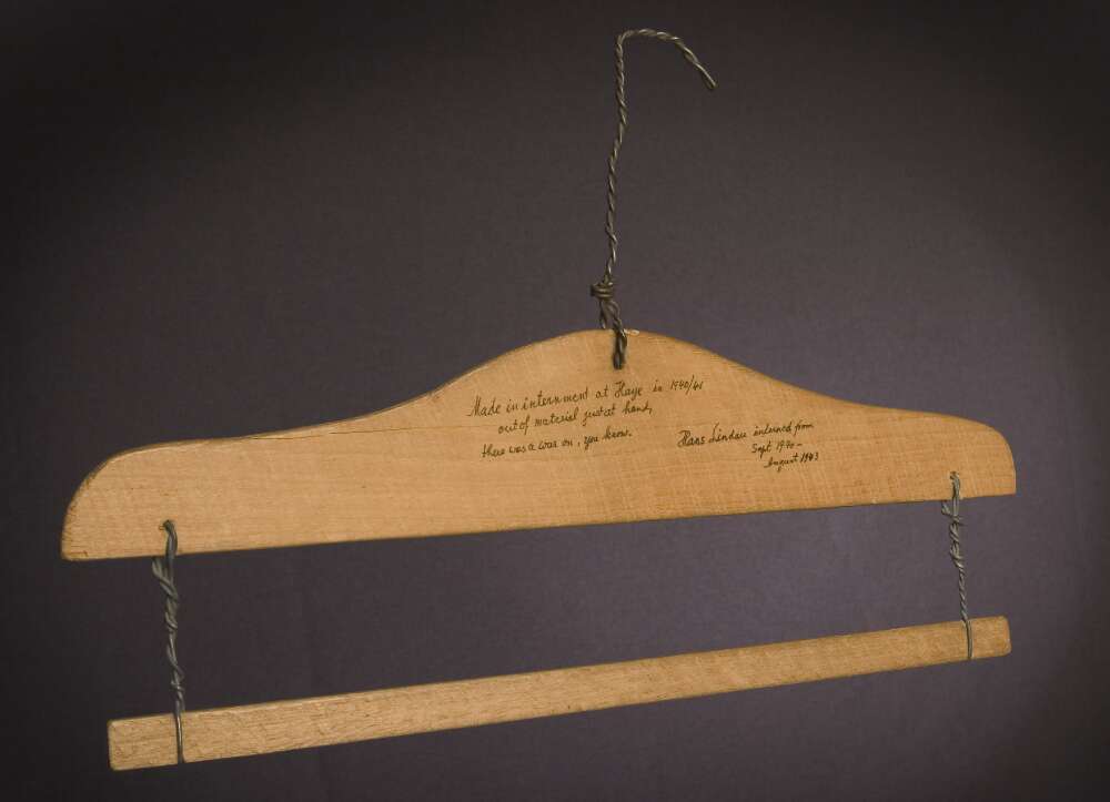 A coat hanger made out of wood. 