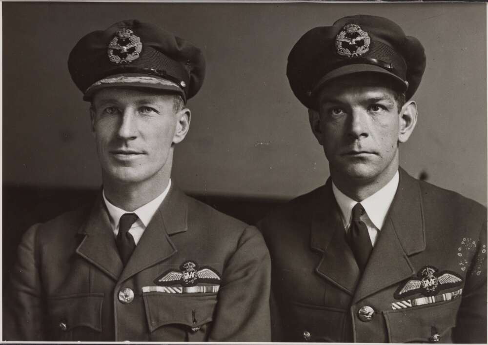 Charles Kingsford-Smith in Royal Australian Airforce Uniform posing for a photograph with Charles Ulm.