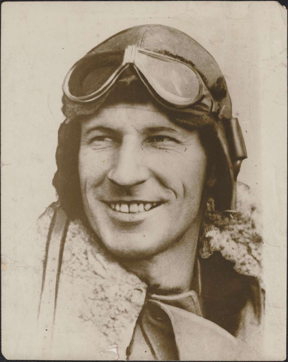 A head and shoulders photograph of Charles Kingsford-Smith with his aviators car and googles on his head.