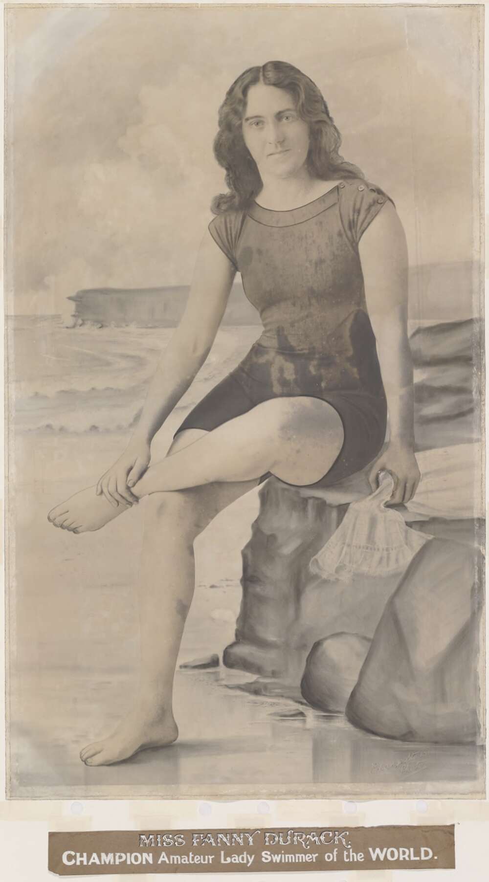 Portrait of Fanny Durack sitting on a rock at a beach