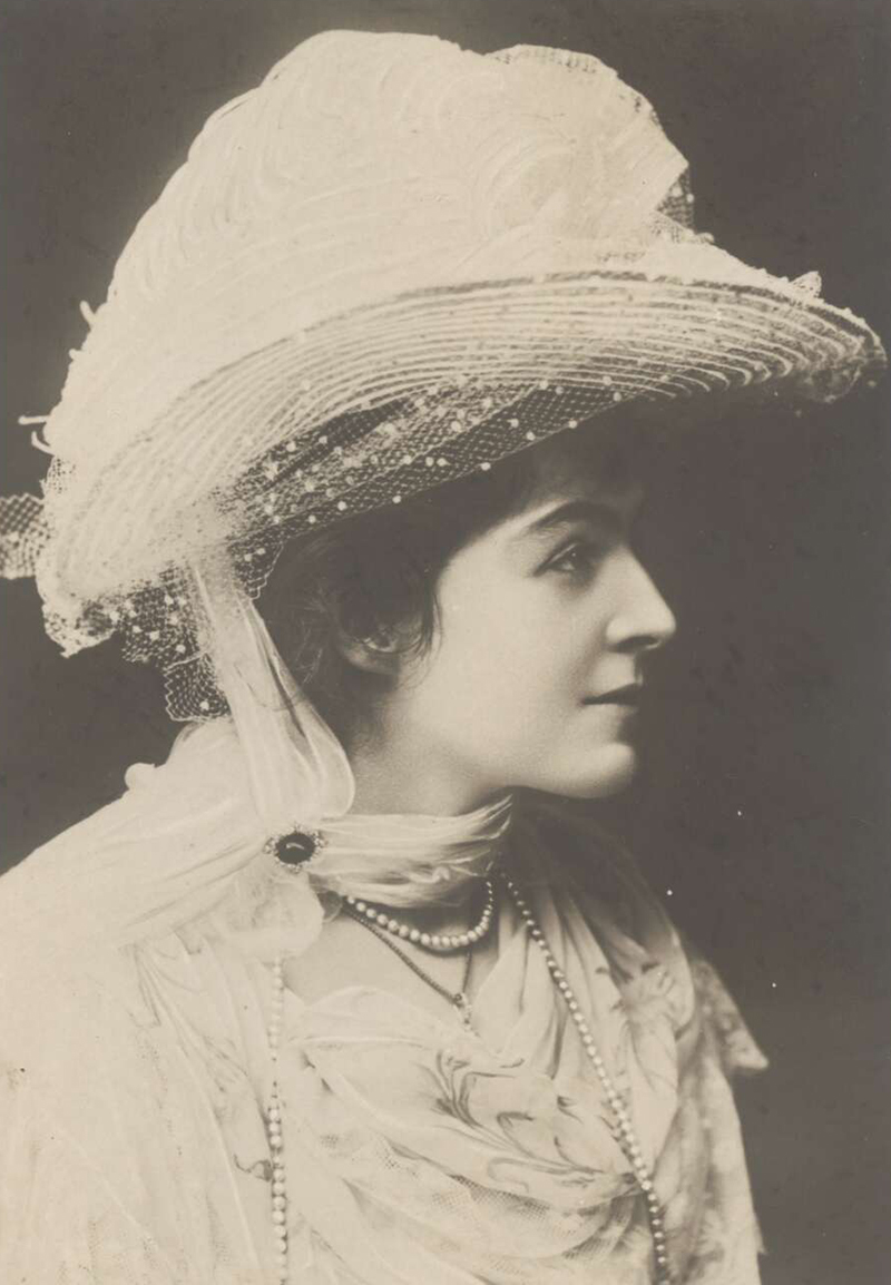 a woman wearing a large hat decorated with tulle