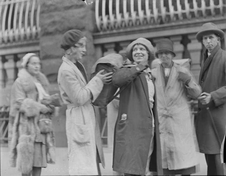 A women helping Amy Simms put her backpack on. 