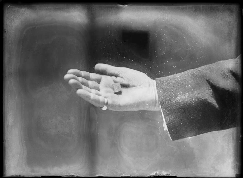 A hand holding a tiny book