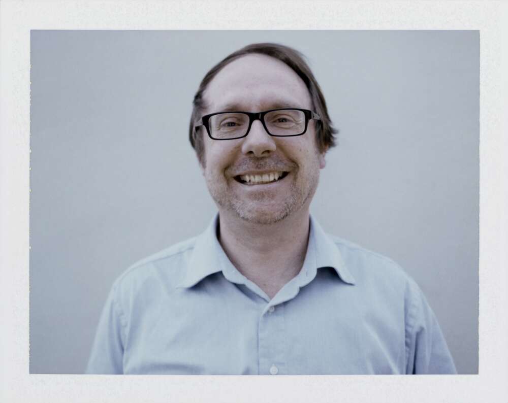 A man in a blue shirt smiling at the camera