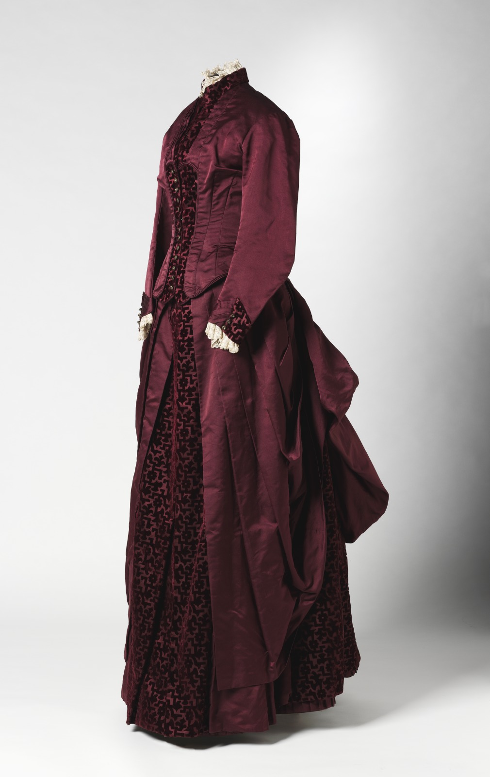 Two-piece full-length dress consisting of a bodice and a skirt in burgundy duchess satin with inserts of cut velvet in a geometric and floral pattern