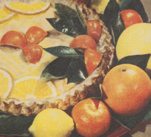 A fruit juice chiffon pie surrounded by various citrus fruits. 