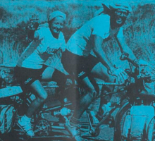Two smiling people riding a tandem bike against a blue background